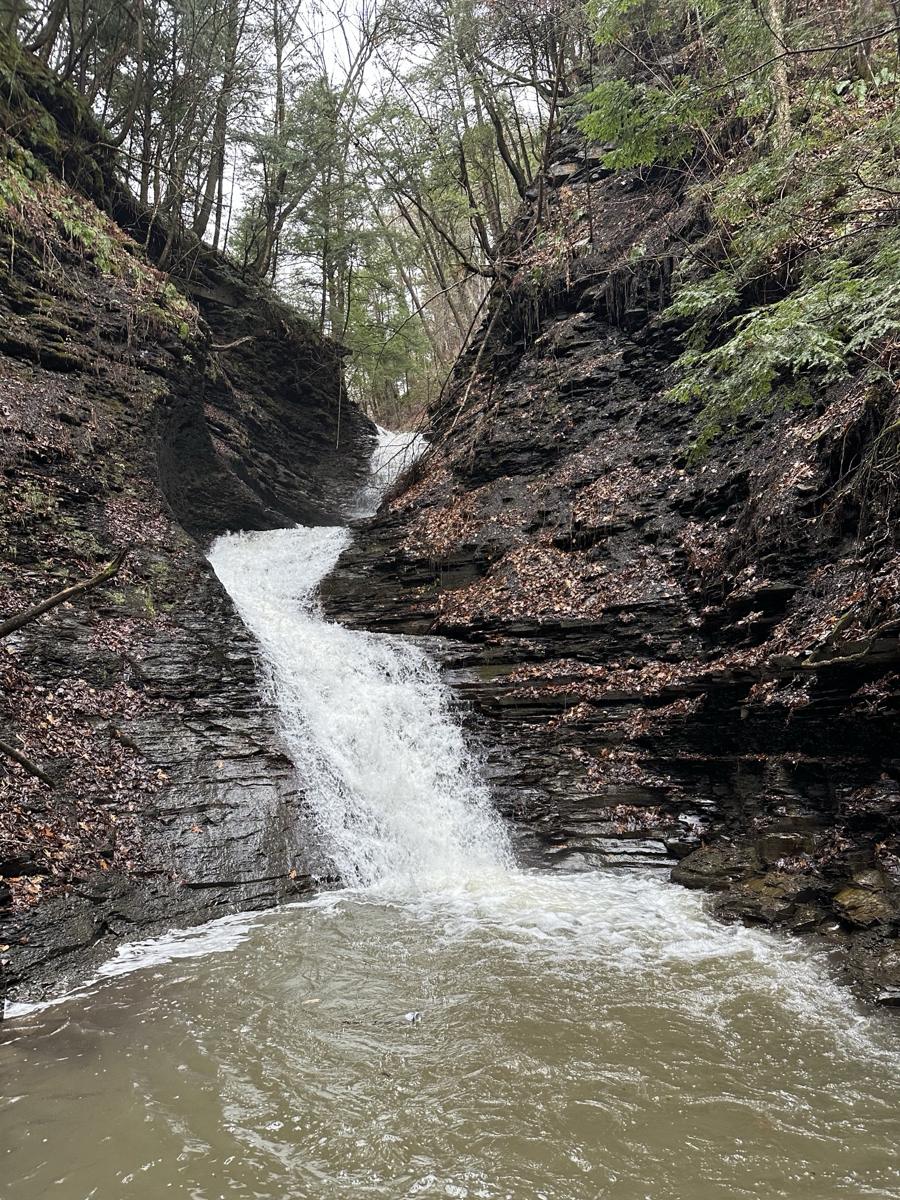 Waterfall at the end of the creek dropping into a pool